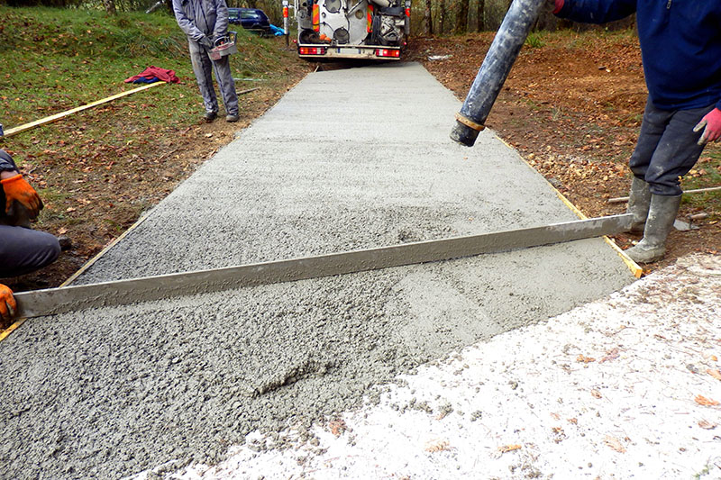 Worker pouring cement onto driveway from the cement lorry